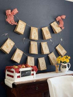 the back to school banner is hanging on the wall next to a table with apples and flowers