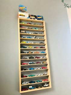 a wooden shelf filled with lots of toy cars