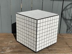 a white and black cube sitting on top of a wooden table