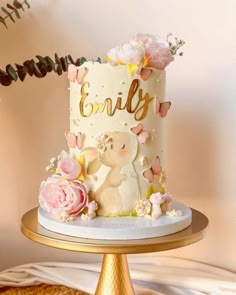 a white cake with pink flowers and gold lettering