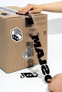 a box with some stickers on it and someone's hand over the top