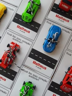 the toy cars are lined up on the table with names and pictures attached to them