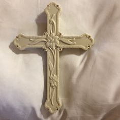 an ornate white cross on a white sheet