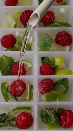 raspberries, limes and mint leaves in ice cubes with water being poured on them