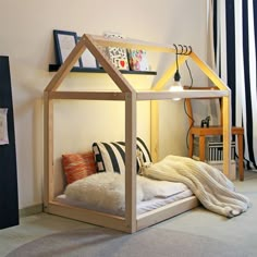 a bed with a house shaped frame on top of it