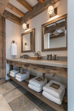 a bathroom with two sinks, mirrors and towels