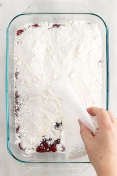 someone is adding ingredients to a dessert in a glass dish