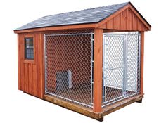 a wooden dog house with a metal fence around it's perimeter and door open