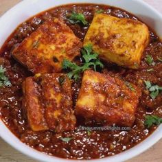 a white bowl filled with tofu and sauce