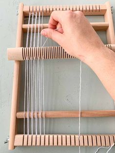 a person is weaving on a wooden frame