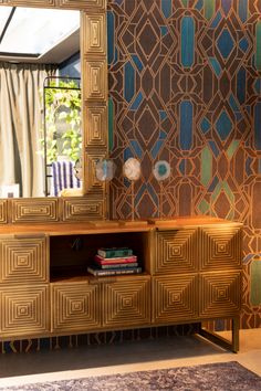 a mirror sitting on top of a dresser next to a wall covered in art deco tiles