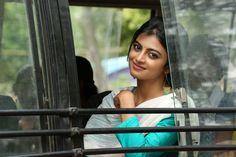 a woman sitting in the driver's seat of a bus looking out the window