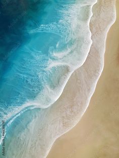 an aerial view of the ocean and beach from above, with waves crashing on it