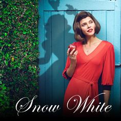 a woman standing in front of a blue door with the words snow white on it