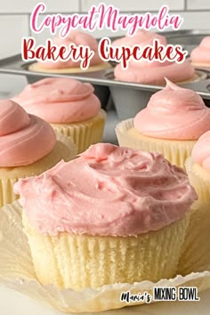 cupcakes with pink frosting sitting on a tray