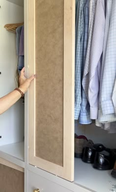 a person is opening the door to a closet with shoes on shelves and shirts hanging up