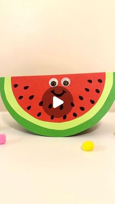 a watermelon cut in half with eyes and nose on it, surrounded by candy