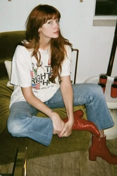 a young woman sitting on top of a green chair next to a white t - shirt