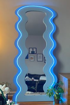 a large mirror sitting on top of a wooden table next to a potted plant