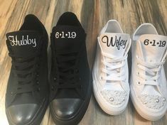 three pairs of black and white shoes with personalized names on the soles are sitting on a wood floor