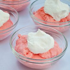 two bowls filled with pink jello and whipped cream on top of each other,