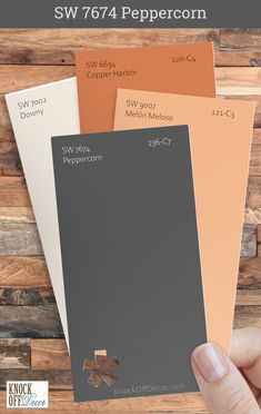 a hand is holding three different colors of paint swatches and the words sw 764 peppercorn