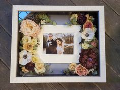 a wedding photo frame with flowers around it