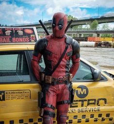 deadpool standing in front of a taxi