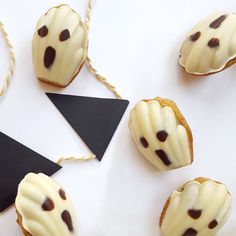 chocolate chip cookies with white icing and black dots on them next to a triangle