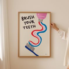 a woman standing in front of a poster with brush your teeth on it's wall