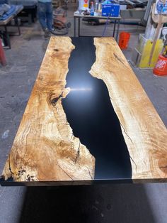 a table made out of wood and black glass in the center, with people working behind it