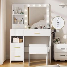 a white vanity with lights on it and a mirror in the corner next to a bed