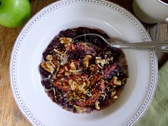 a bowl filled with oatmeal and fruit on top of a wooden table