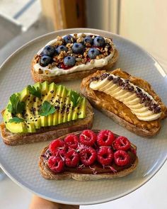 there are four different types of breads on the plate with berries, bananas and kiwi