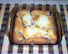 a casserole dish with blueberries in it on a checkered tablecloth