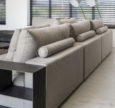 a living room filled with lots of furniture next to windows covered in blindes and shades