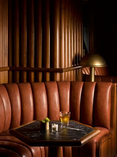 a brown leather booth with two drinks on the table