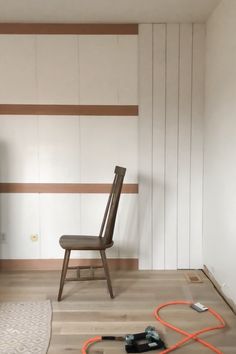 a chair sitting on top of a hard wood floor next to a wall mounted tv