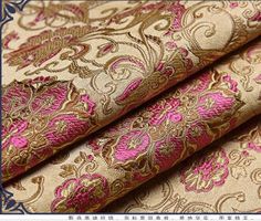 an image of a gold and pink brocaded fabric with paisley designs on it