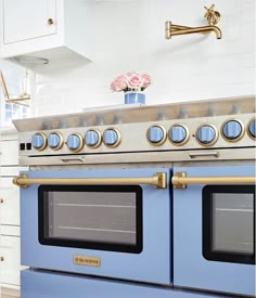 a blue stove top oven sitting inside of a kitchen