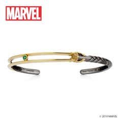 a pair of black and gold bracelets with an emerald in the center, on white background