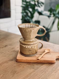 a wooden cutting board topped with a coffee cup