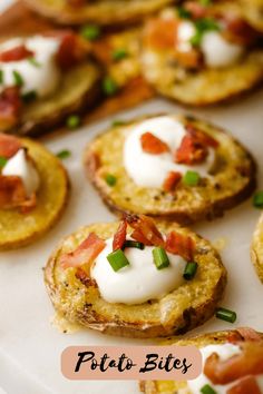 small appetizers are arranged on a plate with green onions and sour cream toppings