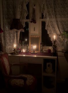 a room with candles lit up in the windows and curtains on the window sill