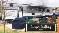 the camper crafting trailer is parked next to some chairs and tables