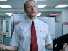 a man in a white shirt and red tie holding a laptop