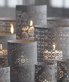 many lit candles are placed next to each other in different patterns and sizes, with one candle burning brightly