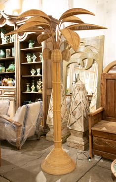 a tall wooden palm tree sitting in a living room next to a chair and mirror