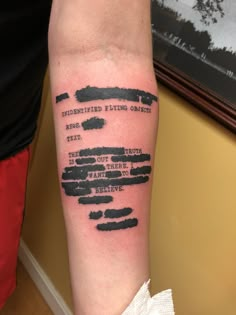 a person with a tattoo on their arm that has words written in black and white