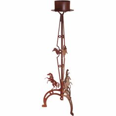 a metal candle holder with horses on it and a hat hanging from the top,